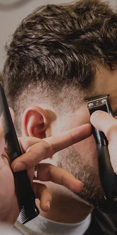Junger Mann mit trendigem Haarschnitt beim Friseur